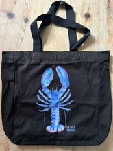 Black tote bag with a blue lobster design 