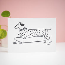 sausage roll sausage dog on a skateboard lino print card